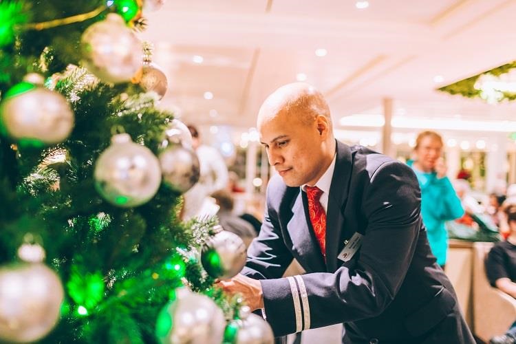 A crew member decorates a holiday tree on a Viking Longship. Photo by Viking.