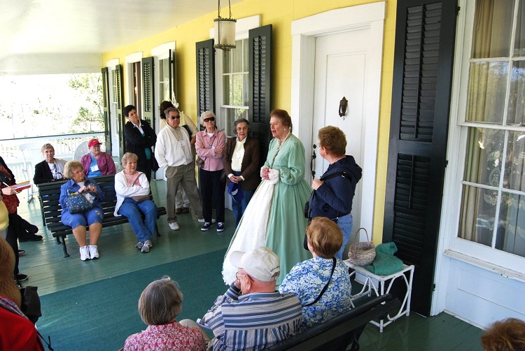 A group participating in a "pilgrimage" tour listen to a guide in period clothing at Hope Farm in the Natchez area. Photo courtesy of Visit Natchez.