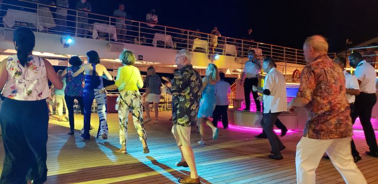 Staying fit on a cruise is sometimes as easy as "going with the flow" such as jumping up spontaneously for line dancing on the top deck. Shown above is the action on Windstar Cruises' Star Breeze in summer 2021. Photo by Susan J. Young.