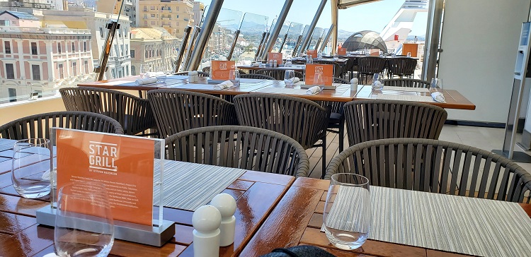 Diners enjoying cuisine at Star Grill by Steven Raithlin dine at outdoor deck tables (covered) and soak up the scenic views off the ship. Photo by Susan Young