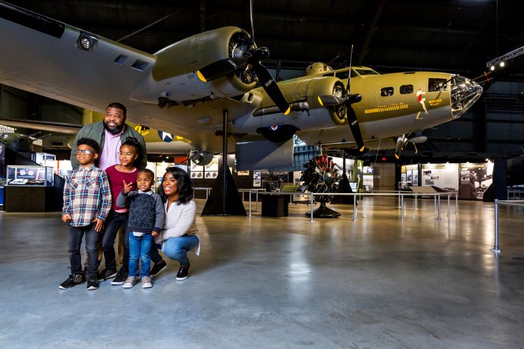 Visitors pose for a photograph in the WWII Gallery at the National Museum of the U.S. Air Force. (U.S. Air Force photo). Photo by Matthew Allen