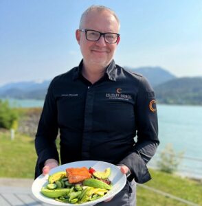 Chef Ethan Stowell with new Alaskan salmon chop with cucumber, tomato, avocado, bacon and green beans. Photo by Holland America Line
