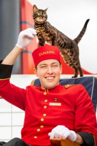 Cats too can sail across the Atlantic on Cunard Line's Queen Mary 2. Here a kitty gets some attention from a Cunard kennel master. Photo by Cunard Line. 