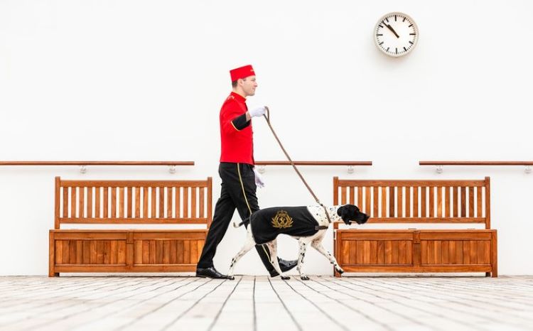 Dog is walked by a Cunard kennel crew member atop the Queen Mary 2. Photo by Cunard Line. 