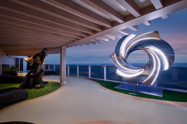 At twilight, the Ocean Concourse is a relaxing place for a walk and soaking up views of art pieces. Photo by Norwegian Cruise Line.
