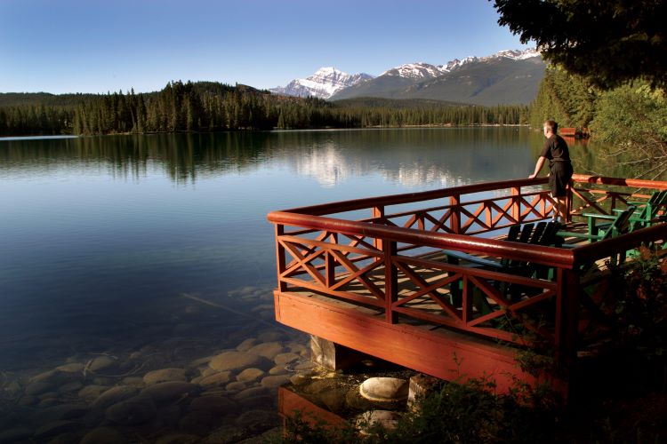 A traveler admires the scenic view from the Fairmont Jasper Park Lodge in Alberta, Canada. Photo by Banff Lake Louise Tourism.