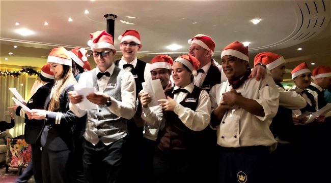 AmaWaterways crew members sing carols during an evening holiday programs in the ship's lounge. Photo by Susan J. Young.