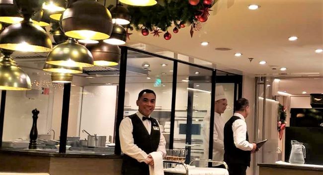 On AmaWaterways' AmaKristina, the Chef's Table is hosted by a chef and waiters, shown here in front of the glass galley. Photo by Susan J. Young.