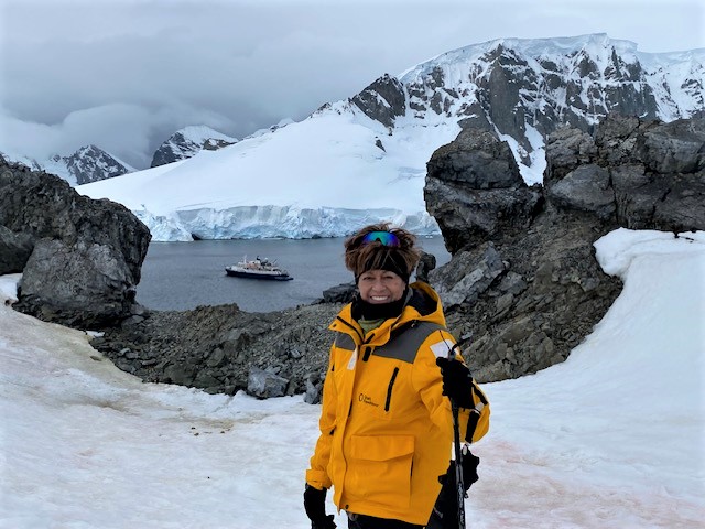 Rose Morrissey, an experienced Pavlus Travel personal travel planner, hikes up a hill in Antarctica. Photo by Rose Morrissey.