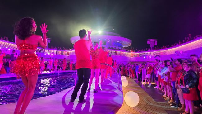 Entertainers line the pool's edge to dance the night away, encouraging guests to join in the fun. Photo by Susan J. Young. 