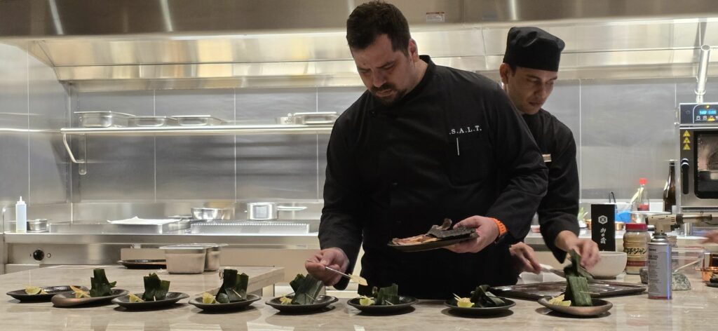 A S.A.L.T. chef prepares one tasting course for guests dining at the new Chef's Table experience in S.A.L.T. Lab during a Silver Nova Asia cruise. Photo by Susan J. Young. 