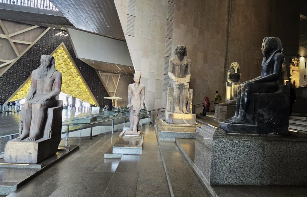 Many ancient statues grace the Grand Staircase within the new Grand Egyptian Museum (GEM) on the Giza Plateau. Photo by Susan J. Young. 