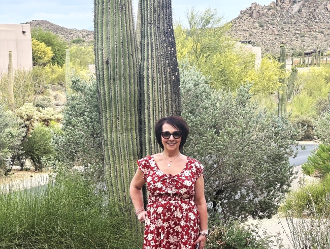 Tracey, a Pavlus Travel personal travel planner, poses with a gigantic cactus in a rural area outside Phoenix, AZ. Photo by Tracey, courtesy of Pavlus Travel.